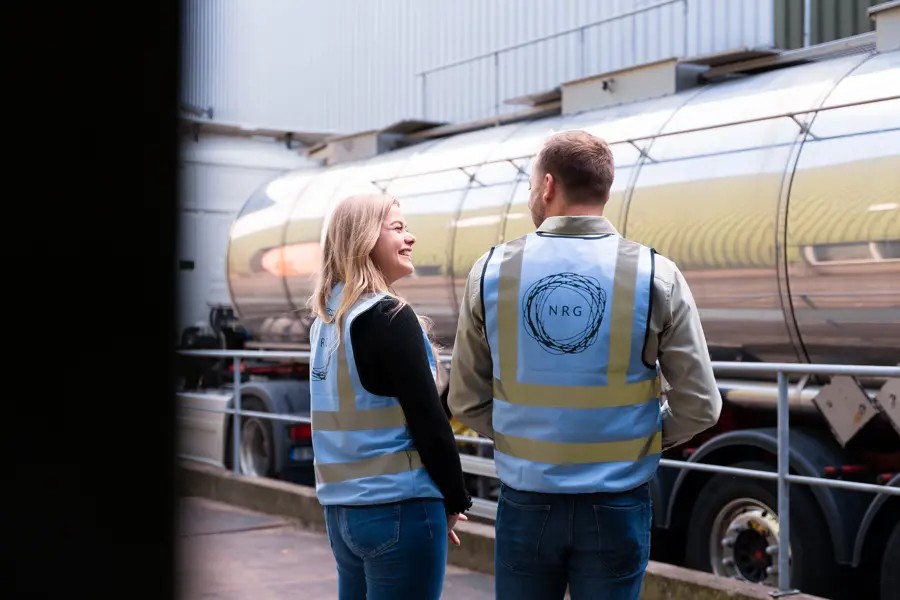 Twee Mensen In Gesprek Met Nrg Office Veiligheidshesjes Naast Een Wagen