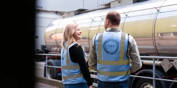 Twee Mensen In Gesprek Met Nrg Office Veiligheidshesjes Naast Een Wagen