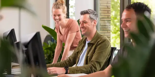 Drie Nrg Office Managers Lachen Naar Een Computerscherm Op Kantoor Zwolle