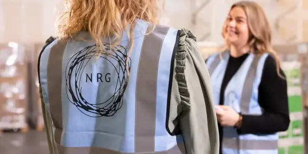 Foto Van De Achterkant Van Een Nrg Office Veiligheidshestje Van Twee Mensen In Gesprek