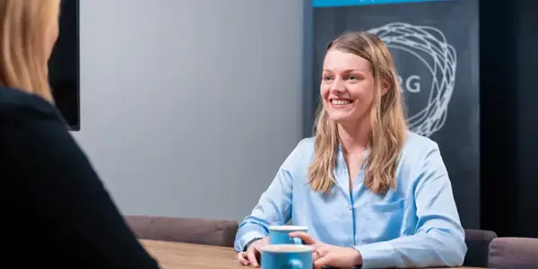 Demand Planner Nicky Is Lachend In Gesprek Met Het Nrg Office Logo Op De Achtergrond