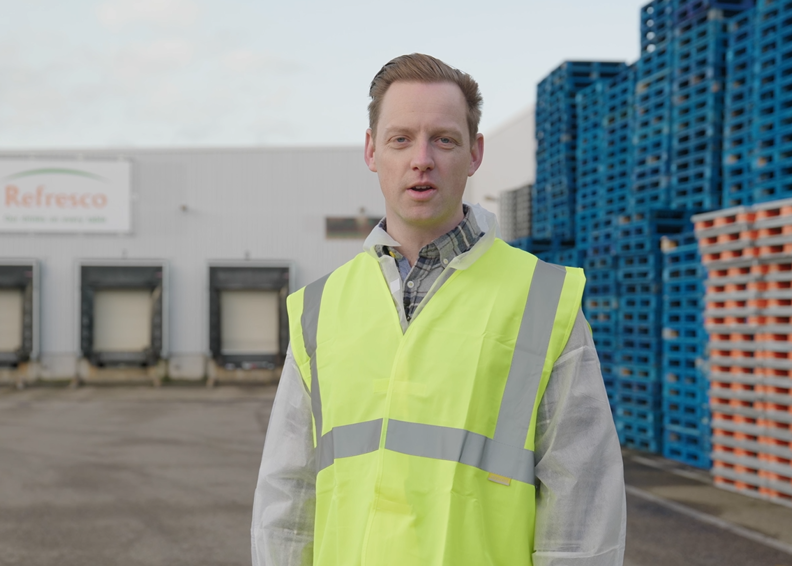 Supply Chain Manager Robin Spreekt In De Camera Met Achter Hem De Business Van Refresco