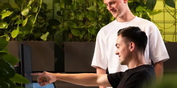 Twee supply chain specialisten kijken naar een computerscherm